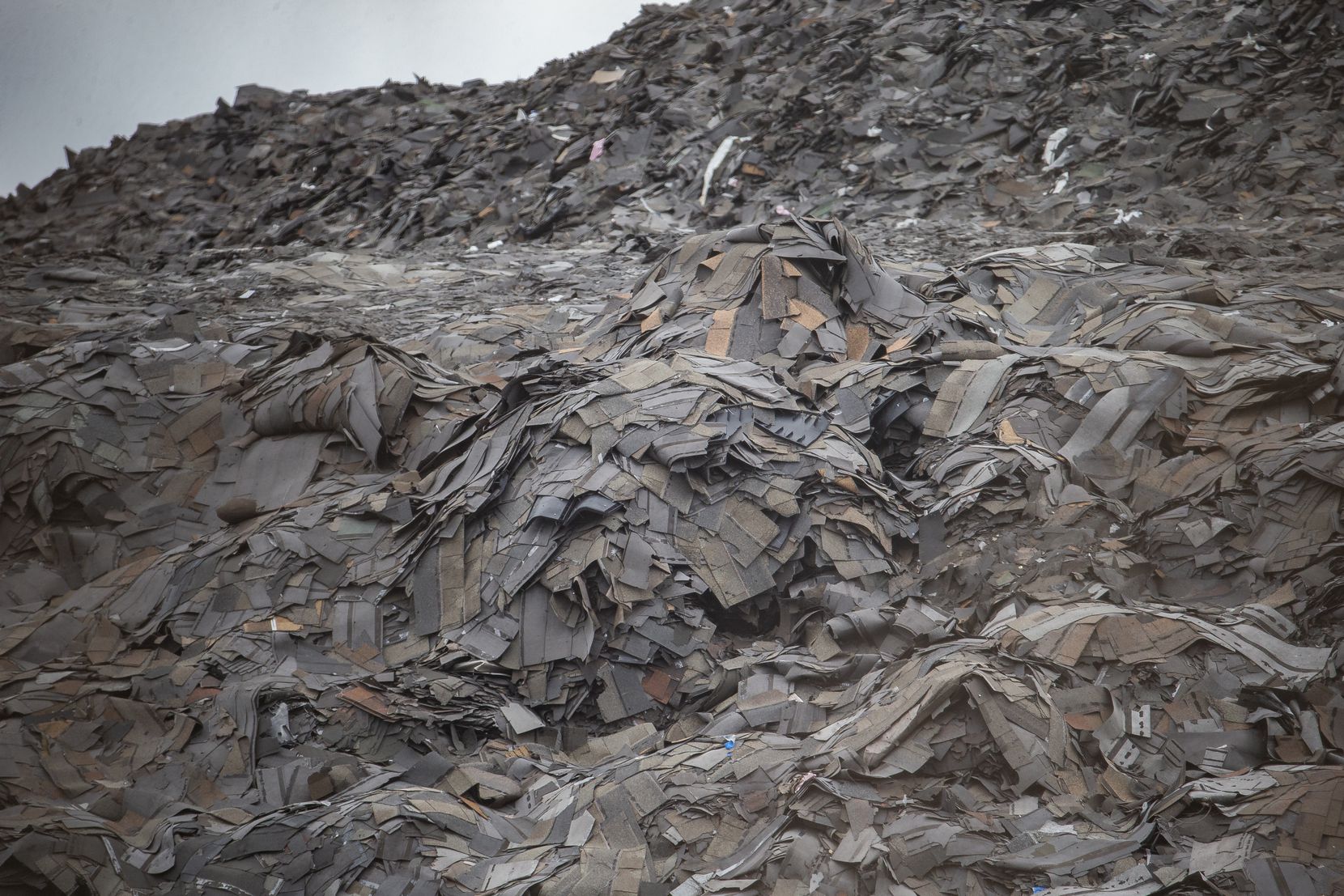 A closeup of the mountain of roofing shingles at what remains of Blue Star Recycling off South Central Expressway in southern Dallas, not too far from Paul Quinn College
