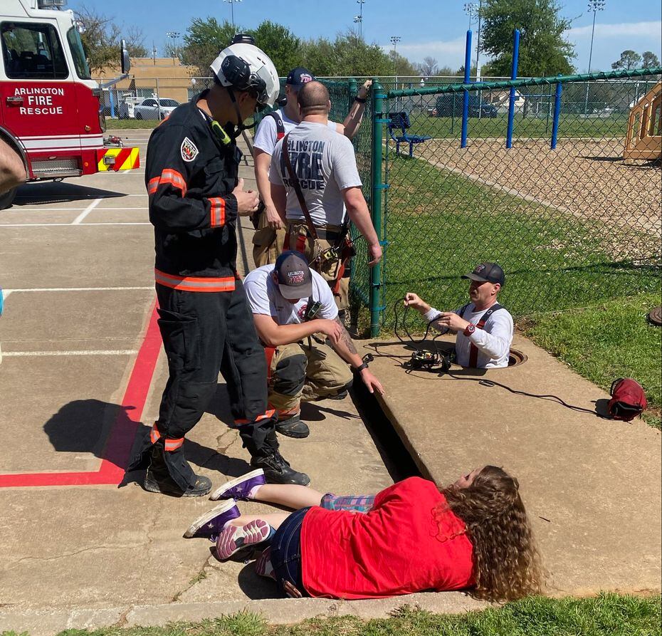 Arlington firefighters work to free a girl from a storm drain as a woman keeps her calm on...