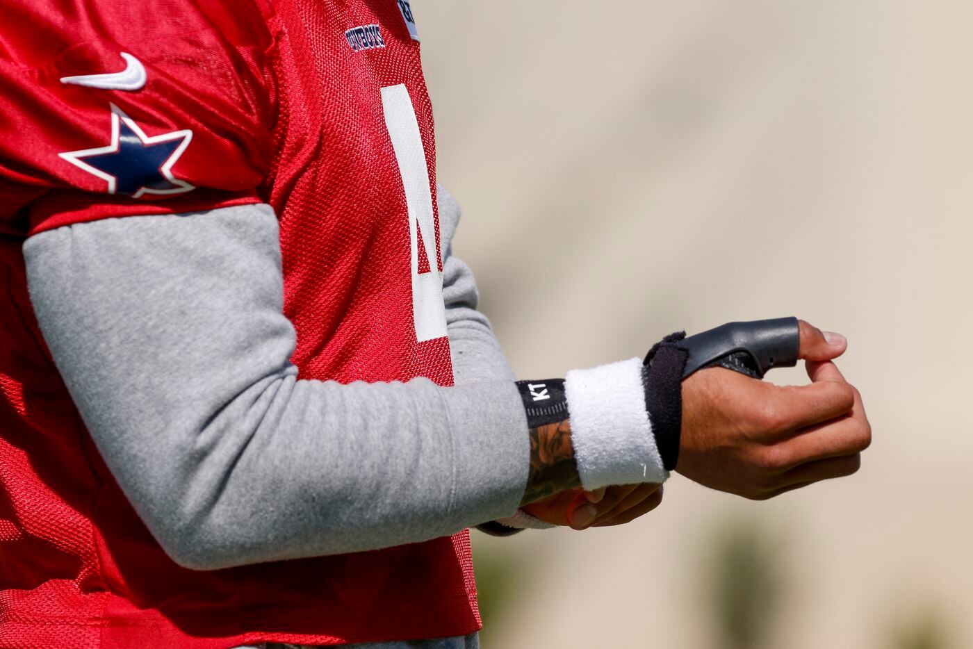 Dallas Cowboys quarterback Dak Prescott (4) adjusts a brace on his injured thumb during a...