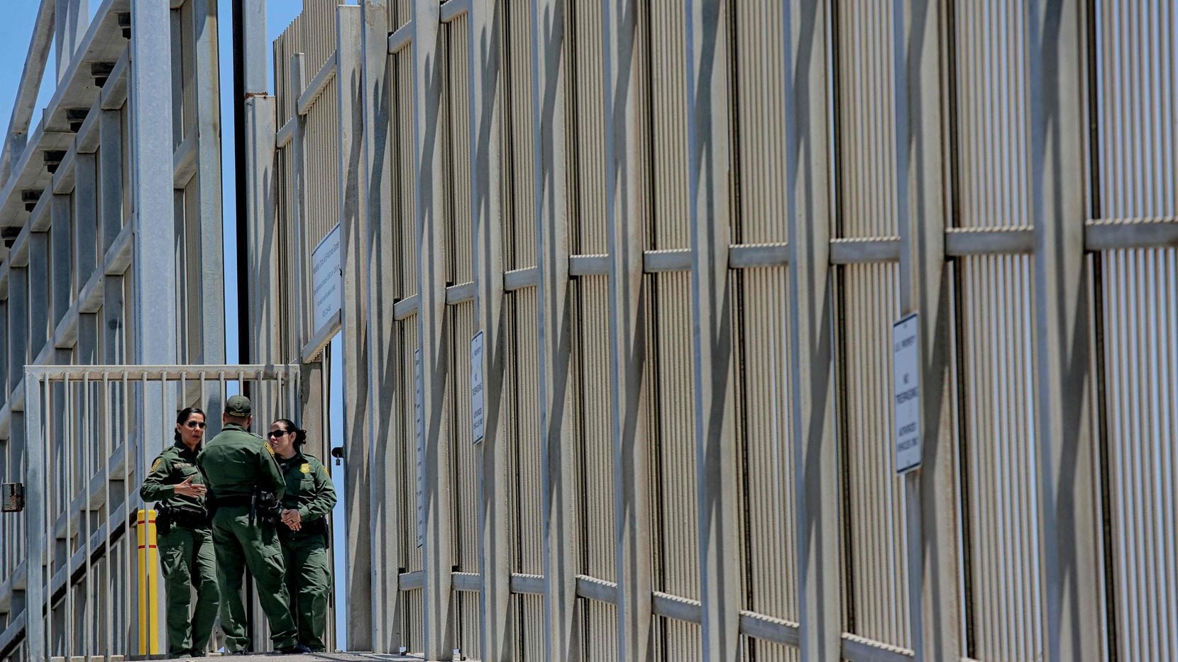 US Customs and Border Protection agents patrol the United States-Mexico Border wall at...