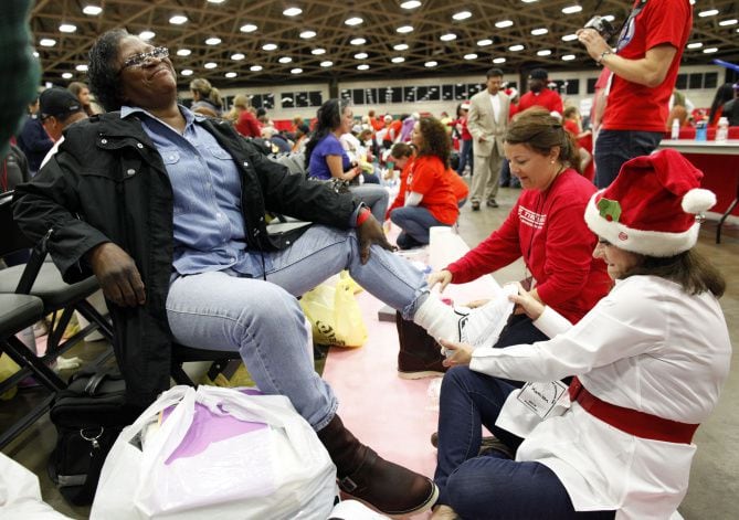 Volunteer Kathleen Turner helped Earnestine Hadnot try on a pair of shoes at Christmas Gift for the Homeless, held Saturday at the Dallas Convention Center. The event was expected to draw 10,000 people, including 5,000 children.