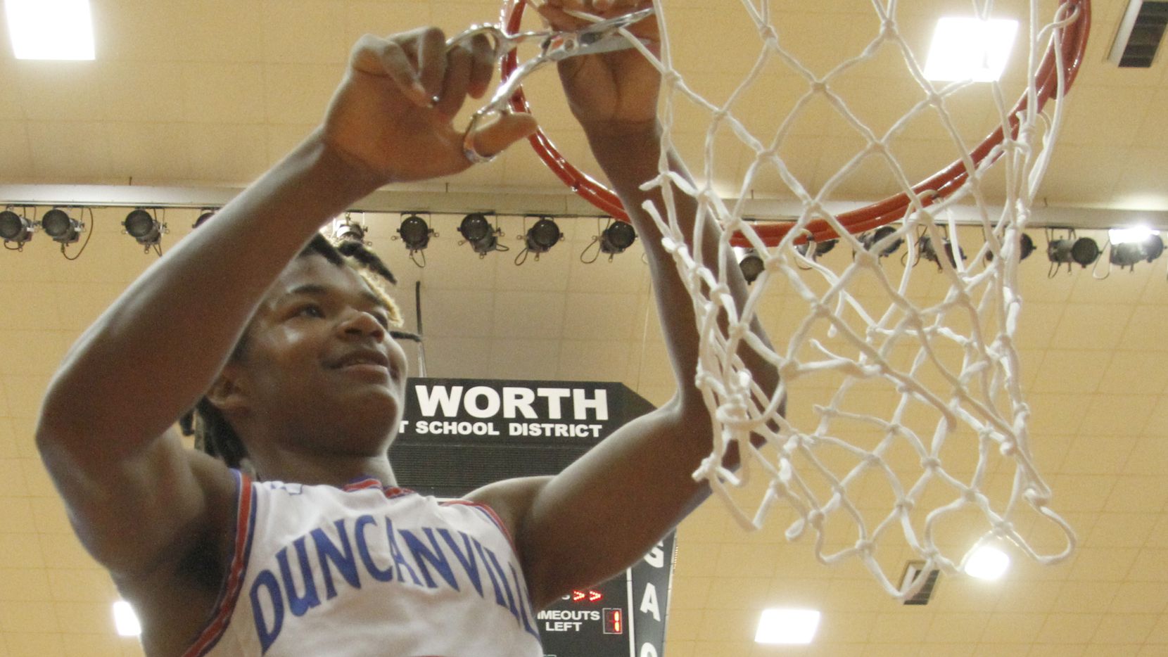 Duncanville guard C.J. Ford (3) was all smiles as he cuts a portion of the net from the rim...