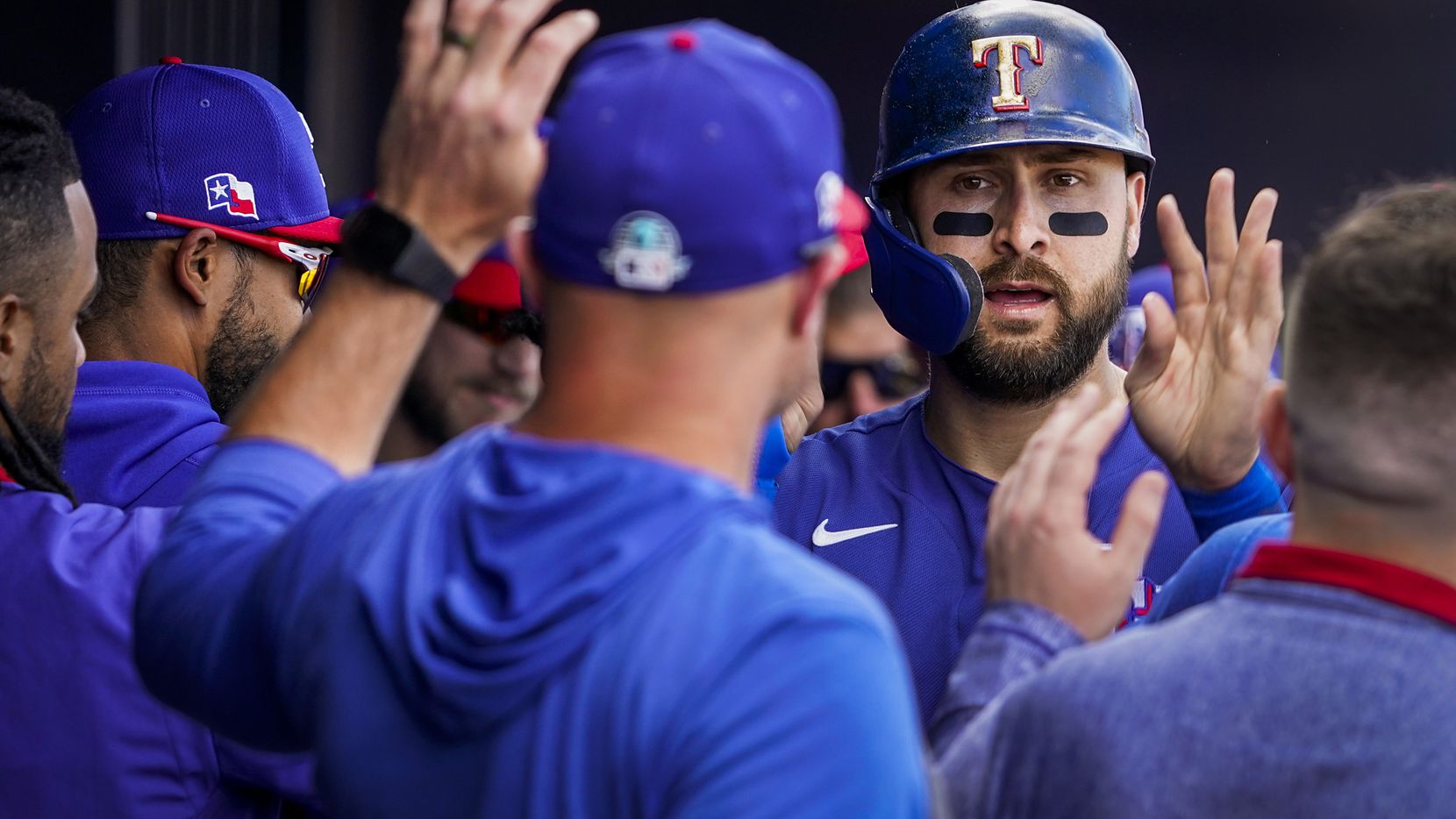 Texas Rangers outfielder Joey Gallo celebrates with teammates after scoring on a single by...