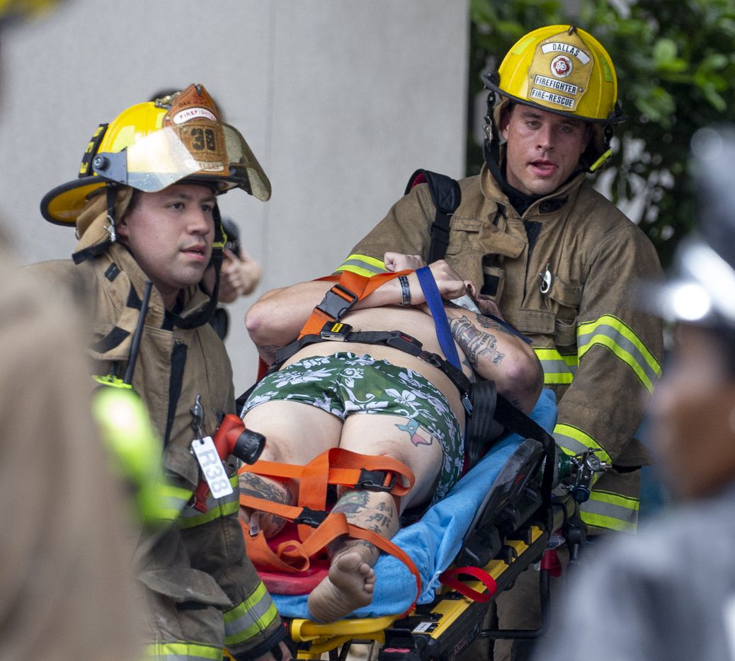 Officials carried a man on a stretcher after a crane collapsed into Elan City Lights apartments in Dallas on Sunday, June 9, 2019. 