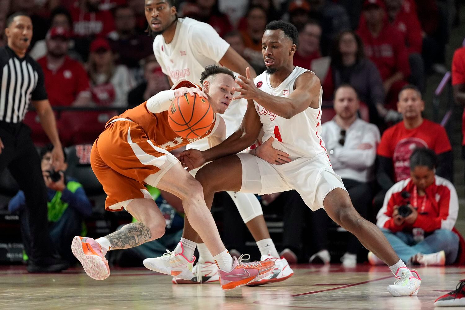 Houston's L.J. Cryer (4) defends against Texas' Chendall Weaver (2) during the second half...