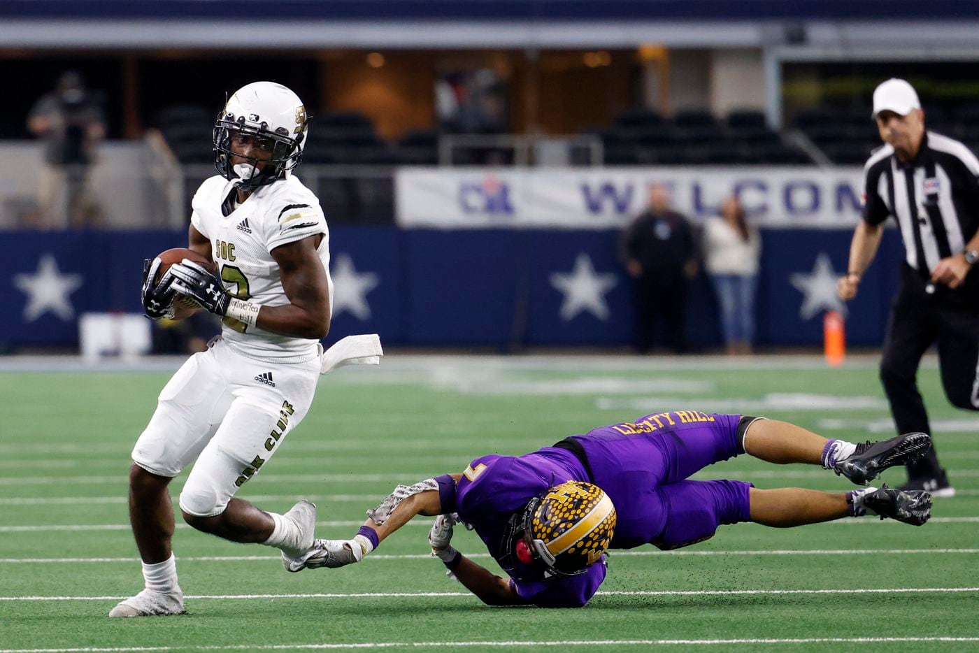 South Oak Cliff running back Ke'Undra Hollywood (12) slips the tackle of Liberty Hill linebacker Devin Riley (7) during the second half of their Class 5A Division II state championship game at AT&T Stadium in Arlington, Saturday, Dec. 18, 2021. South Oak Cliff defeated Liberty Hill 23-14 for Dallas ISD’s first title since 1958. (Elias Valverde II/The Dallas Morning News)
