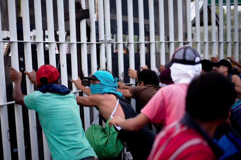Inmigrantes de centroamérica tratan de cruzar la barrera entre Guatemala y México el domingo...