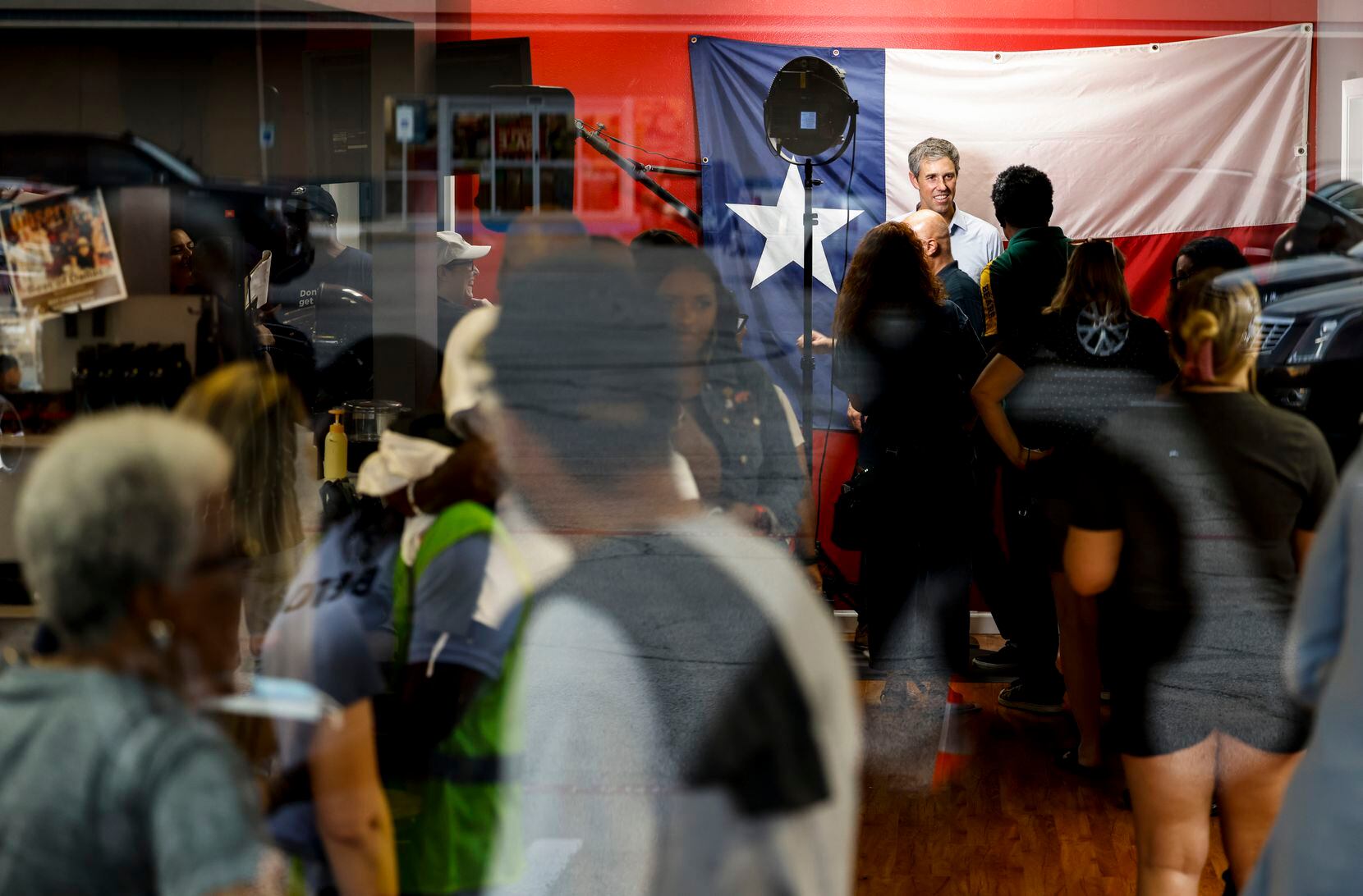 Supporters are reflected on a glass window as Texas Governor candidate Beto O'Rourke...