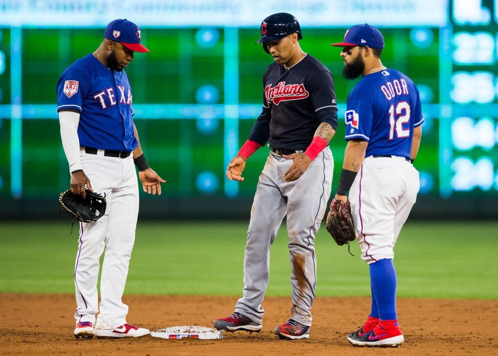 Texas Rangers shortstop Elvis Andrus (1) and second baseman Rougned Odor (12) give Cleveland Indians designated hitter Hanley Ramirez (2) a hard time at second base during the third inning of a spring training baseball game between the Texas Rangers and the Cleveland Indians on Monday, March 25, 2019 at Globe Life Park in Arlington. (Ashley Landis/The Dallas Morning News)