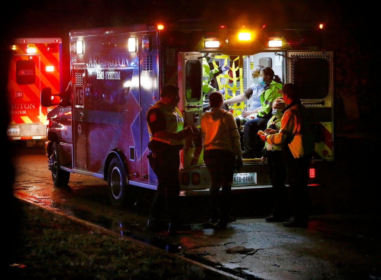 A person is treated in an ambulance after a tornado-wired storm blew the roofs off The Mirage Apartments complex on Pioneer Parkway in Arlington, Tuesday night, November 24, 2020. Air conditioner units and other structural debris were scattered across the property and street.