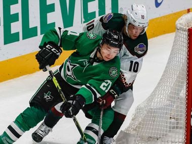 Dallas Stars left wing Jason Robertson (21) goes around Arizona Coyotes center Ryan Dzingel (10) with the puck as goaltender Scott Wedgewood (31) protects the net during third period at the American Airlines Center in Dallas on Monday, December 6, 2021.