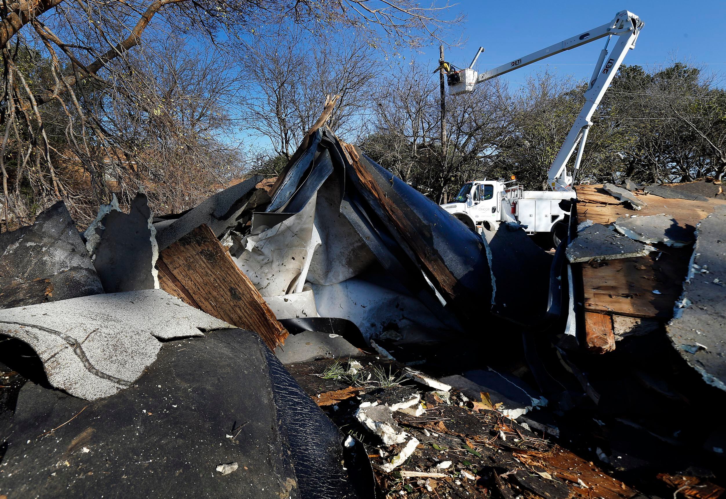 A n Oncor crew restores power to debris-strewn Pioneer Parkway in Arlington after a a...