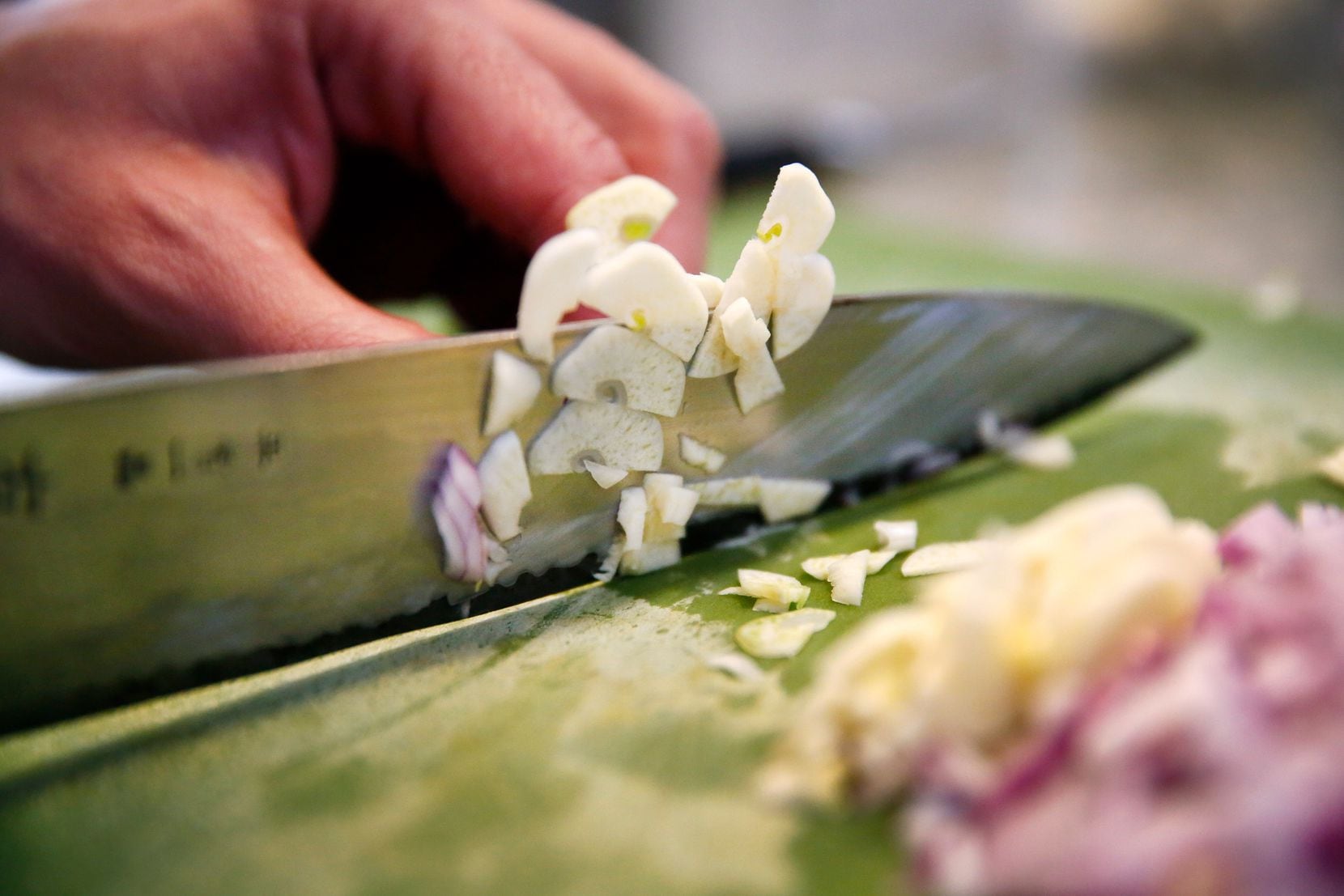 Barsotti slices garlic and red onion. (Tom Fox/Staff Photographer)