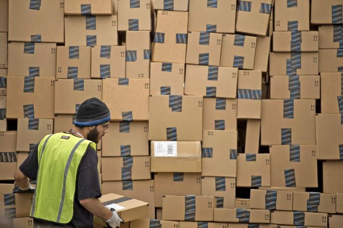 An employee loads a truck at an Amazon.com fulfillment center in Phoenix. In Texas, where...