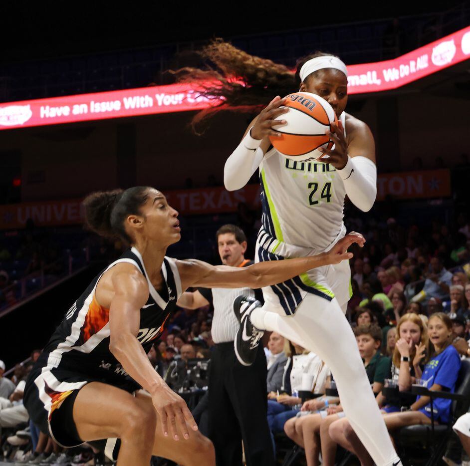 Dallas Wings guard Arike Ogunbowale (24) leaps to keep the ball in bound as she is defended...