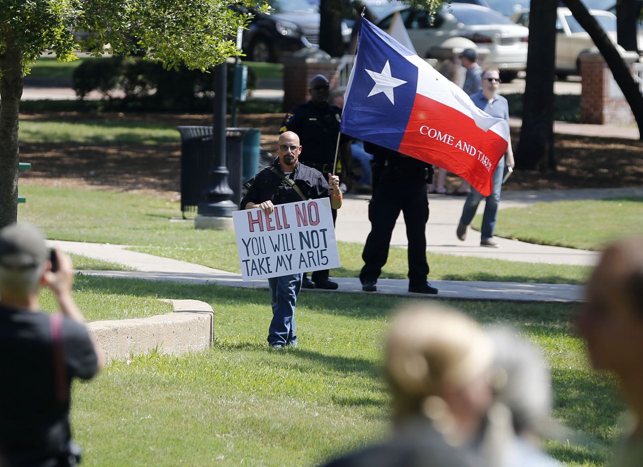 John Swicegood holds up a sign that reads "Hell no you will not take my AR15," at a campaign...