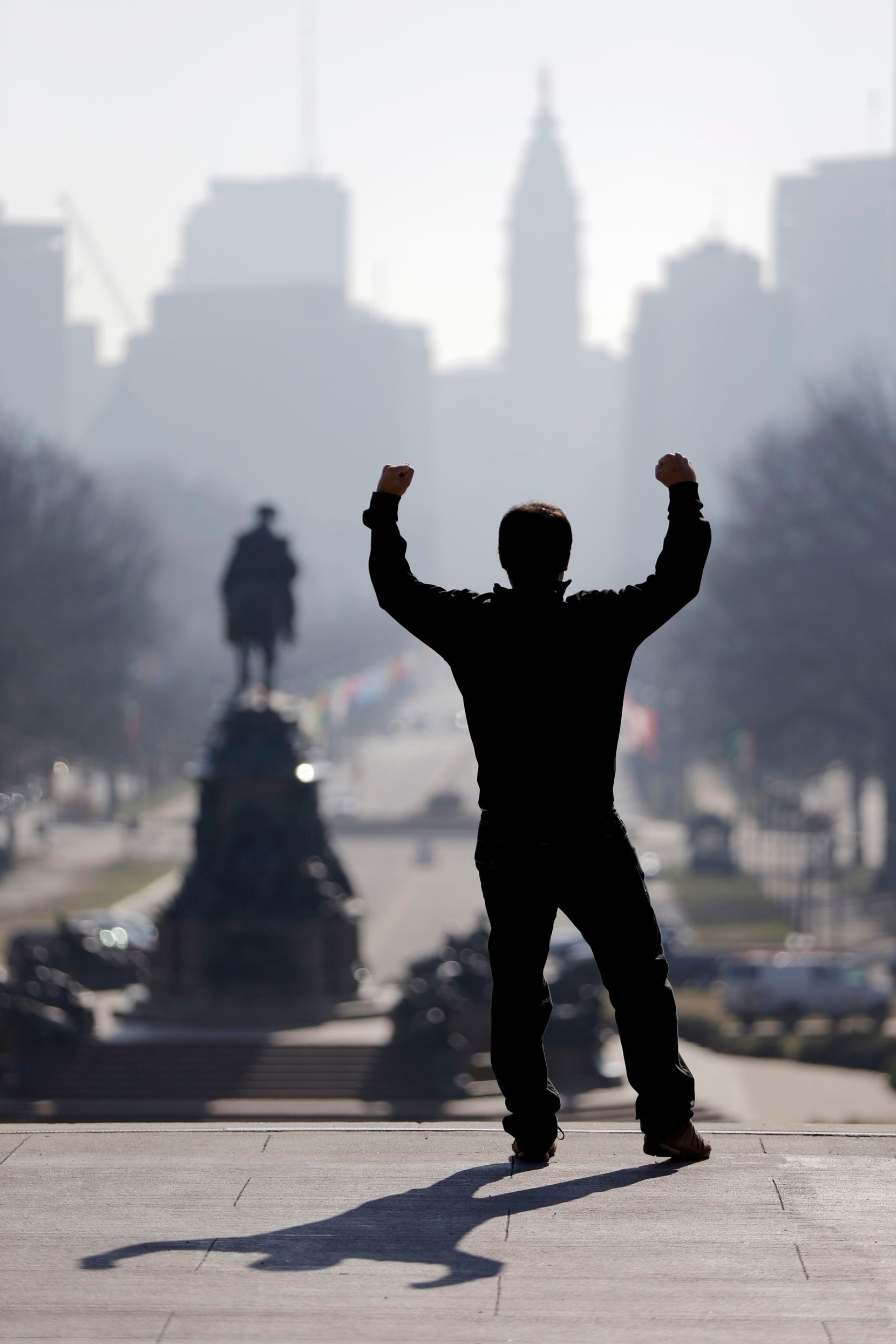 A tourist imitates the character Rocky Balboa from the 1976 movie "Rocky," on the steps of...