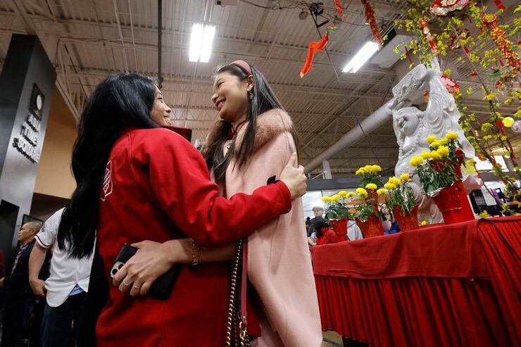 Michelle Tran, Vietnamese descendant, of Las Colinas, left, greets her friend June Loh,...