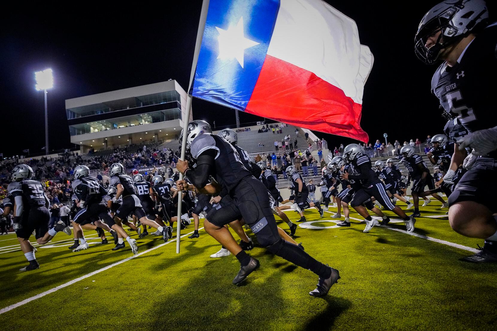 Denton Guyer linebacker  Leo Gibbs (10) carries the Texas flag as they Wildcats take the...