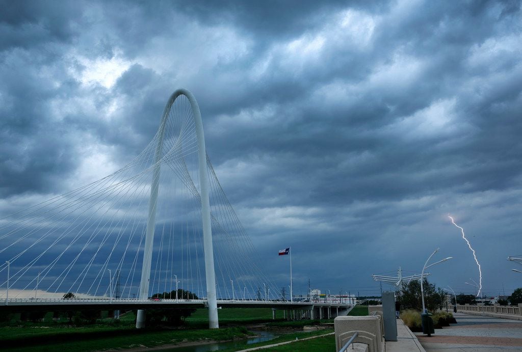 Lightning strikes in West Dallas as a thunderstorms roll past the Margaret Hunt Hill Bridge,...