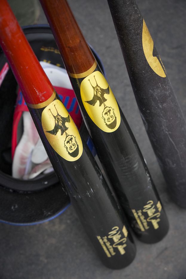 Texas Rangers outfielder Willie Calhoun’s bats and helmet sit ready in the dugout during a...