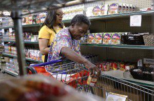  Alisha Brown, left, a volunteer for North Texas Food Bank helps Glenda Rittenhouse choose...