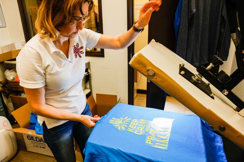 Store owner Olena Jacobs, works on t-shirts in support of Ukraine throughout the day at Ukie...