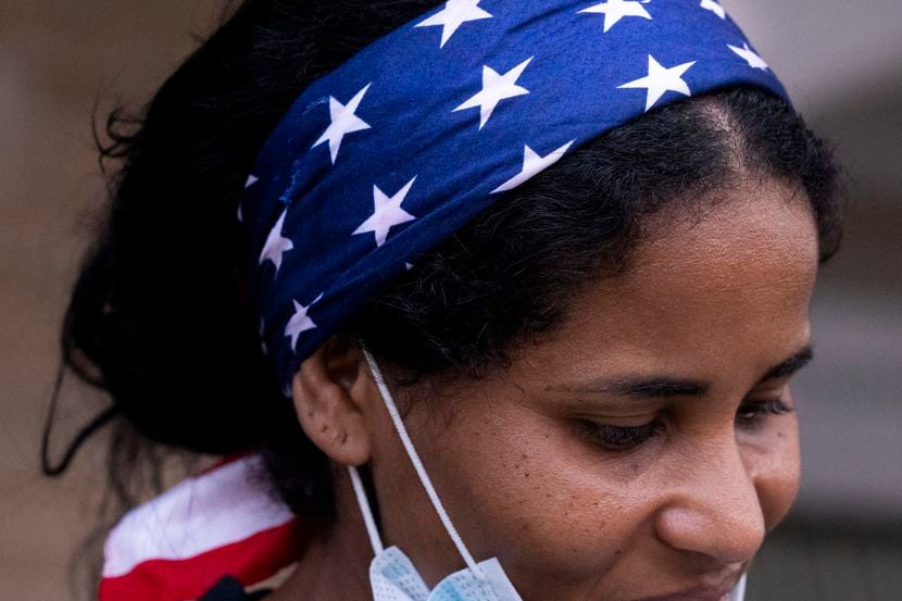 Yoima Paisan-Viltre, wearing a red-white-and-blue bandana, waits for family members after...