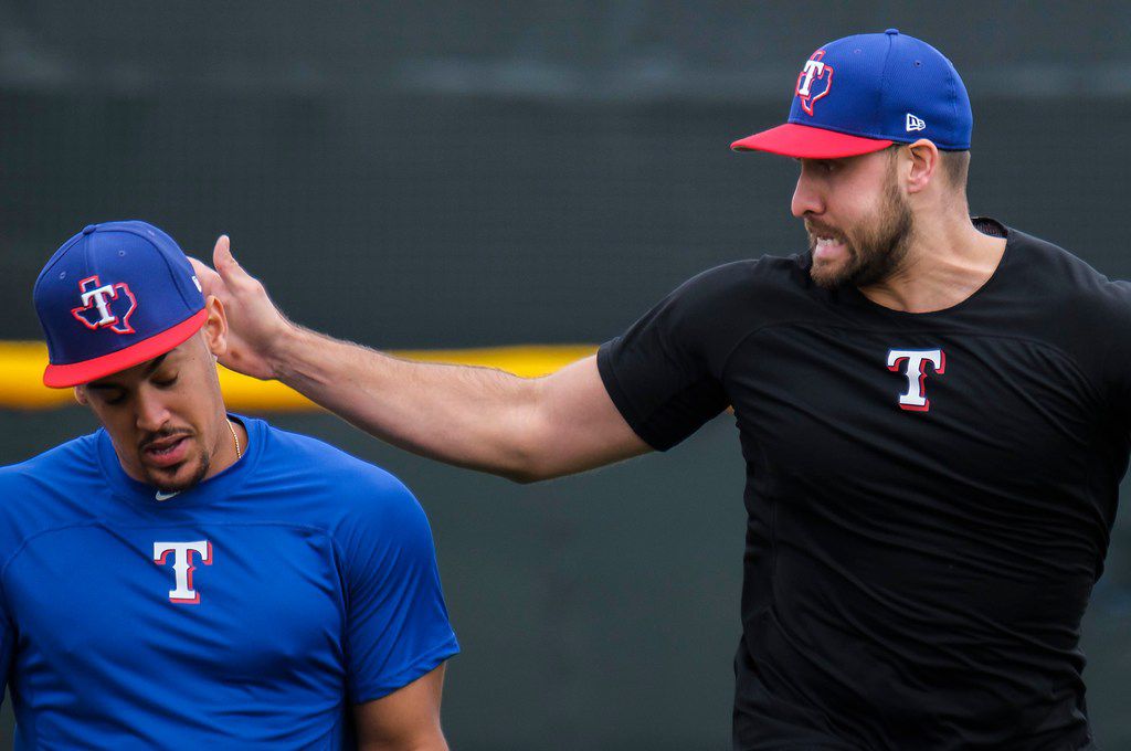 Texas Rangers outfielder Joey Gallo sneaks up behind infielder Ronald Guzman and taps him on...