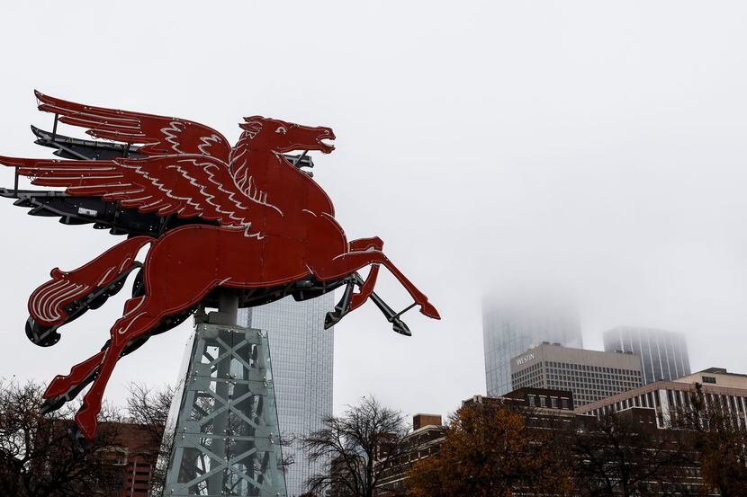El Pegaso rojo, un de los símbolos de la ciudad, se revela en medio de un día de niebla en...