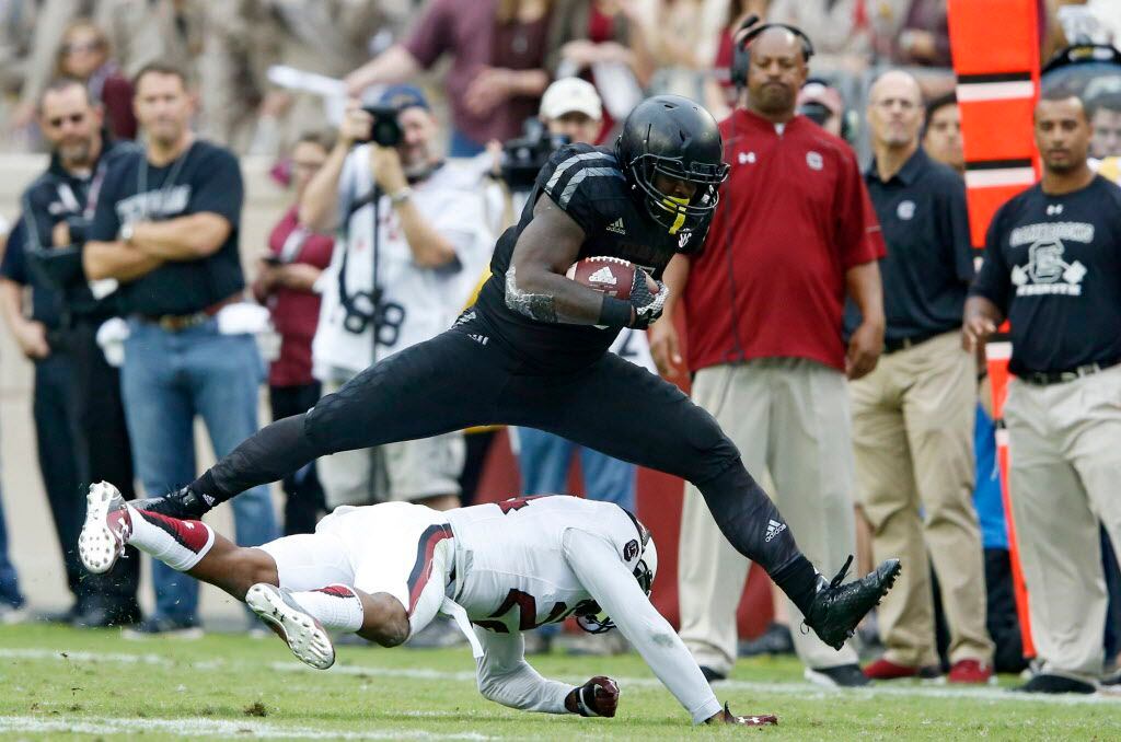 Texas A&M Aggies running back Tra Carson (5) leaps over South Carolina Gamecocks safety D.J. Smith (24) for a first down during the second half of play at Kyle Field in College Station, on Saturday, October 31, 2015. Texas A&M Aggies defeated South Carolina Gamecocks 35-28. (Vernon Bryant/The Dallas Morning News)
