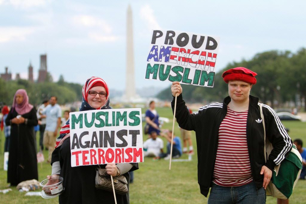 People hold banners during the Americans Against Terrorism, Hate and Violence rally on the...