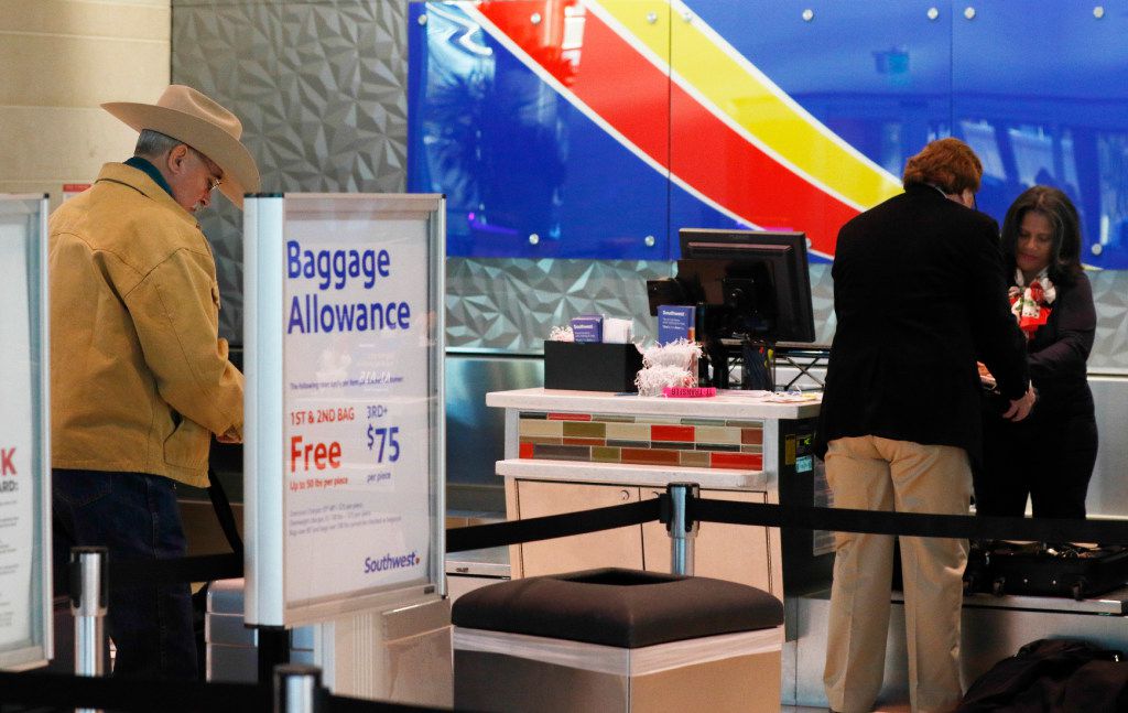 Southwest Airlines passenger Hugh Hubert (left) waits to check in at Dallas Love Field on...