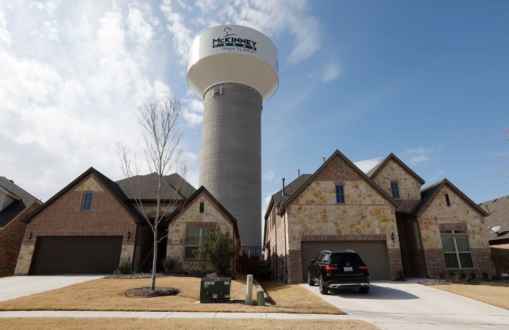 A McKinney water tower looms behind new homes on Leadville Way in McKinney.