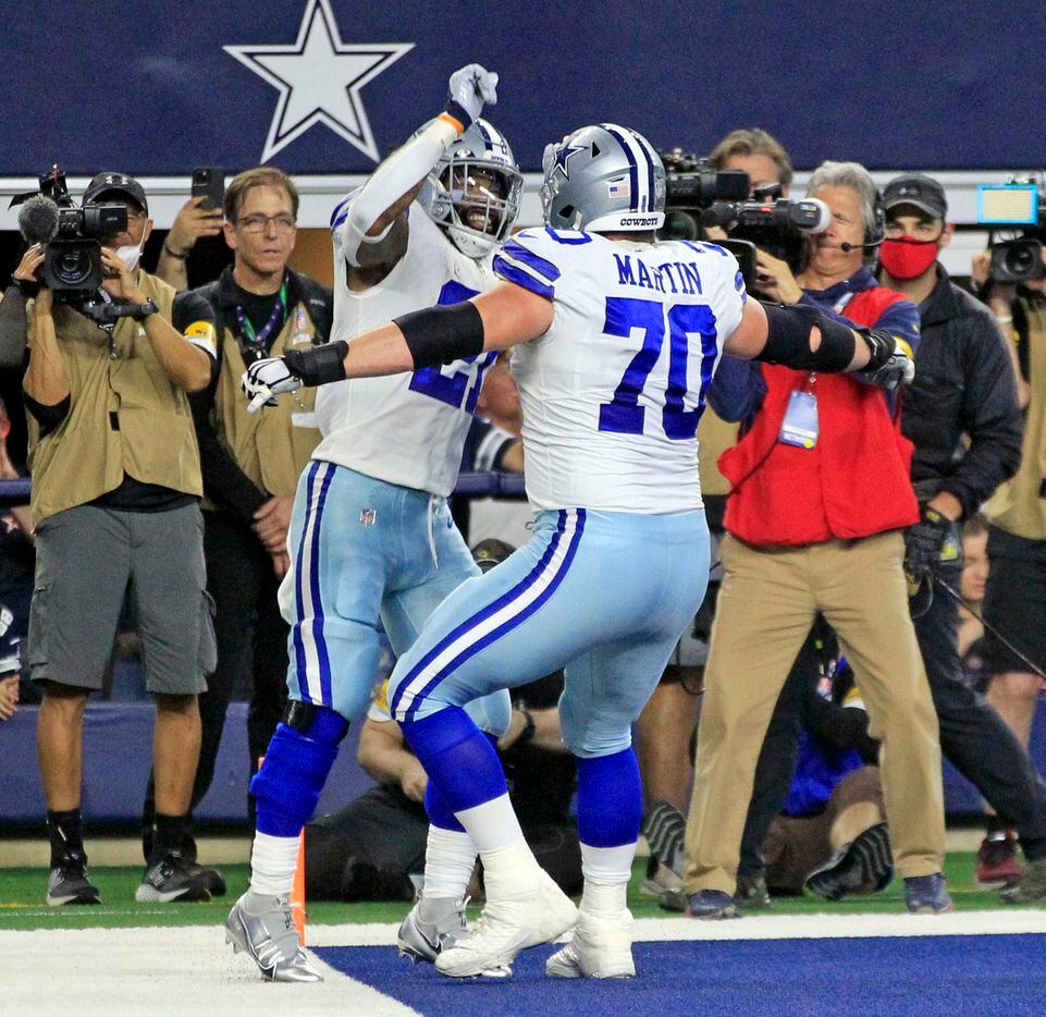 Dallas Cowboys running back Ezekiel Elliott (21) and teammate Zack Martin (70) celebrate...