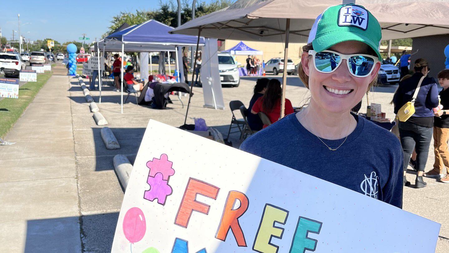 Woman carries sign at event for Annie's Place