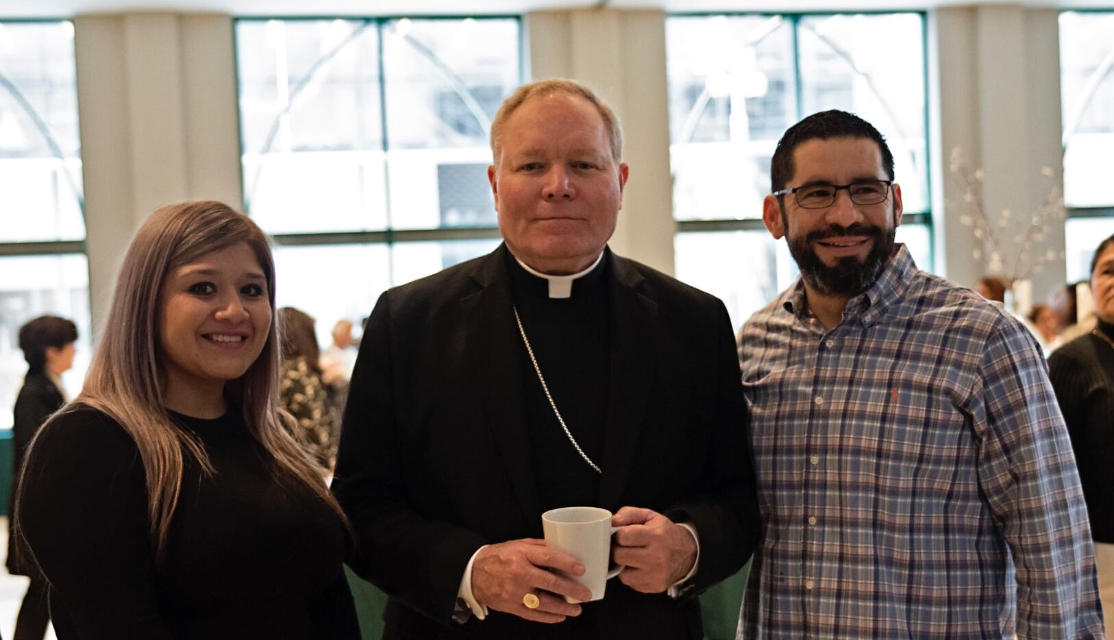 Bishop Edward Burns poses for a photo with nurse Magali Reynoso (left) and Dallas SWAT...
