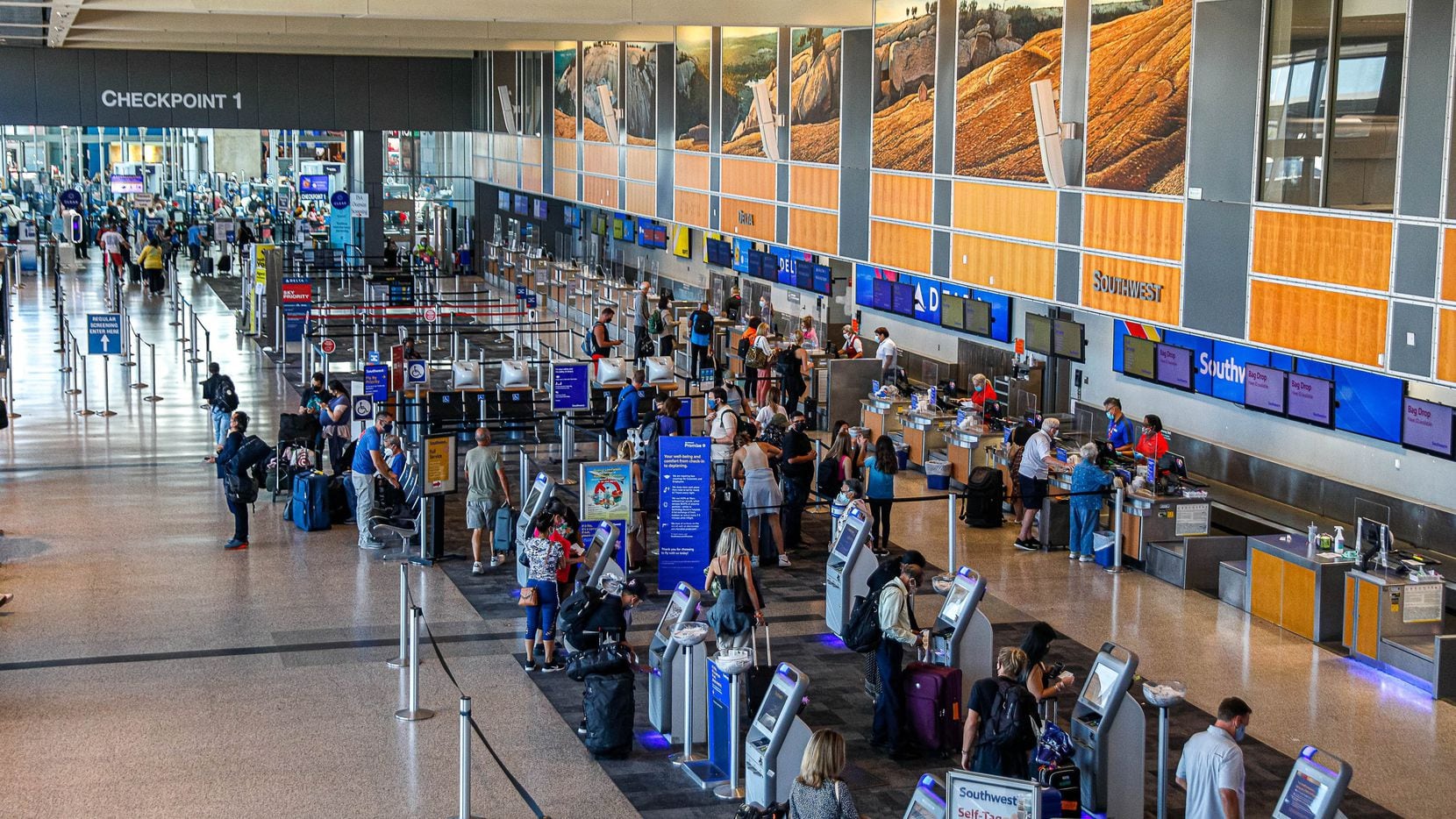 Travelers fill the lines at the Southwest Airlines counters while other airline sit almost...