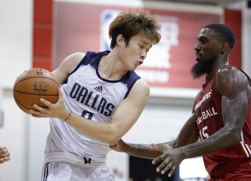 Dallas Mavericks' Ding Yanyuhang, left, of China, drives around Miami Heat's Okaro White...