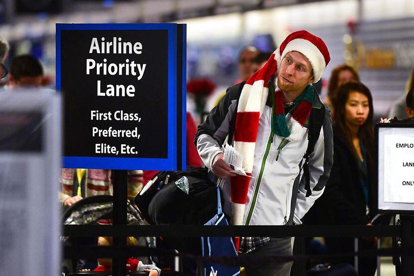 Amos Darnell hace fila en el aeropuerto de Charlotte, N.C., con espíritu navideño. Para...