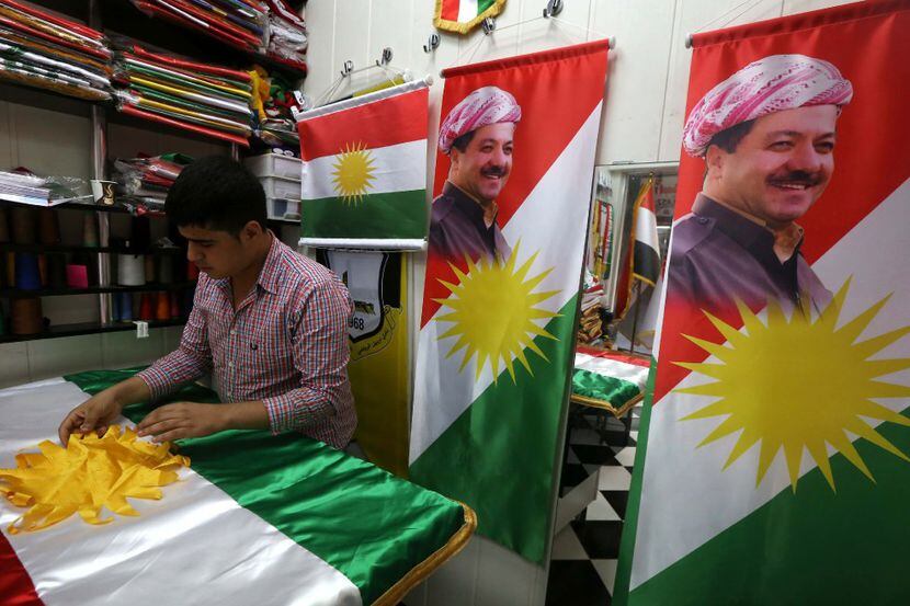 This file photo taken on August 20, 2015, shows a man sewing an Kurdish flag bearing a...