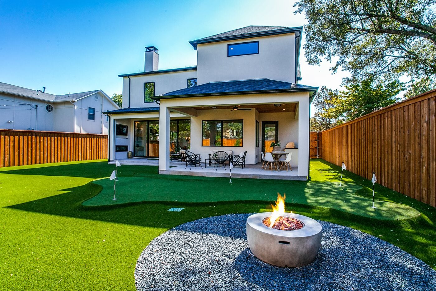 Bonus backyard features include a mini putting green, a dog run, a fire pit and turf.