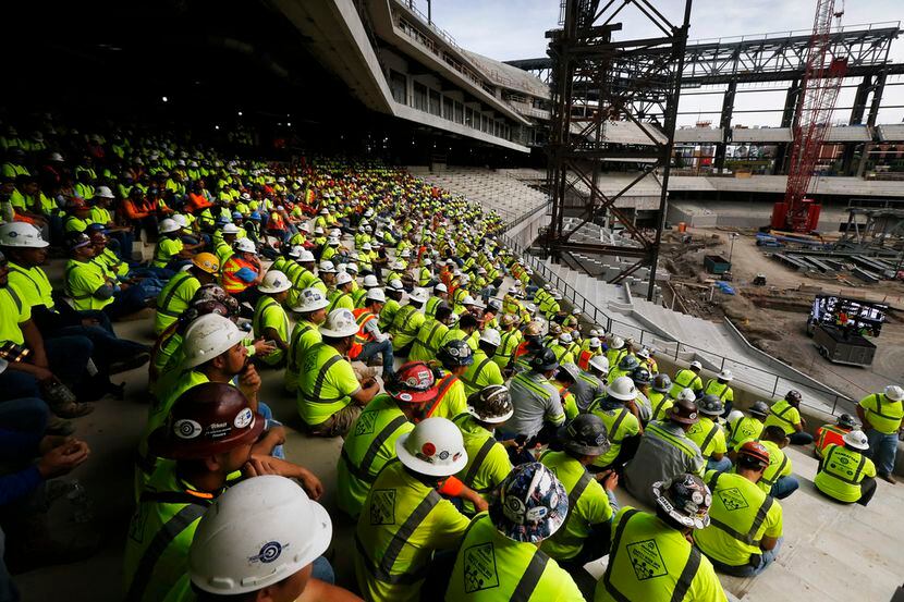 Grupos de trabajadores de construcción en el nuevo estadio de los Rangers, aún en...