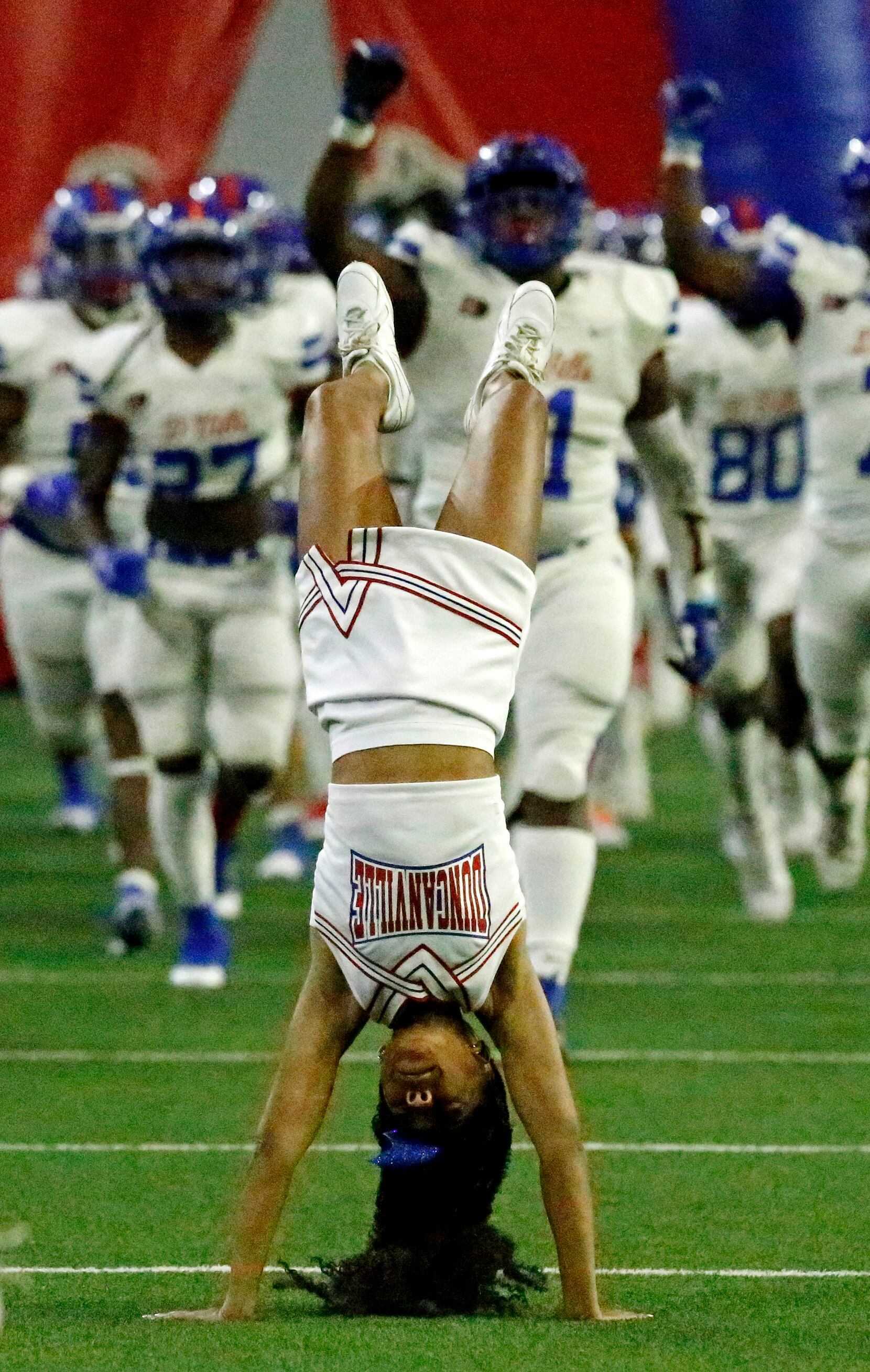 Duncanville cheerleaders do backflips in front of their team entering the field before kickoff  as Duncanville High School played Spring High School in a Class 6A Division I Region II semifinal football game at The Ford Center in Frisco on Saturday, November 27, 2021. (Stewart F. House/Special Contributor)