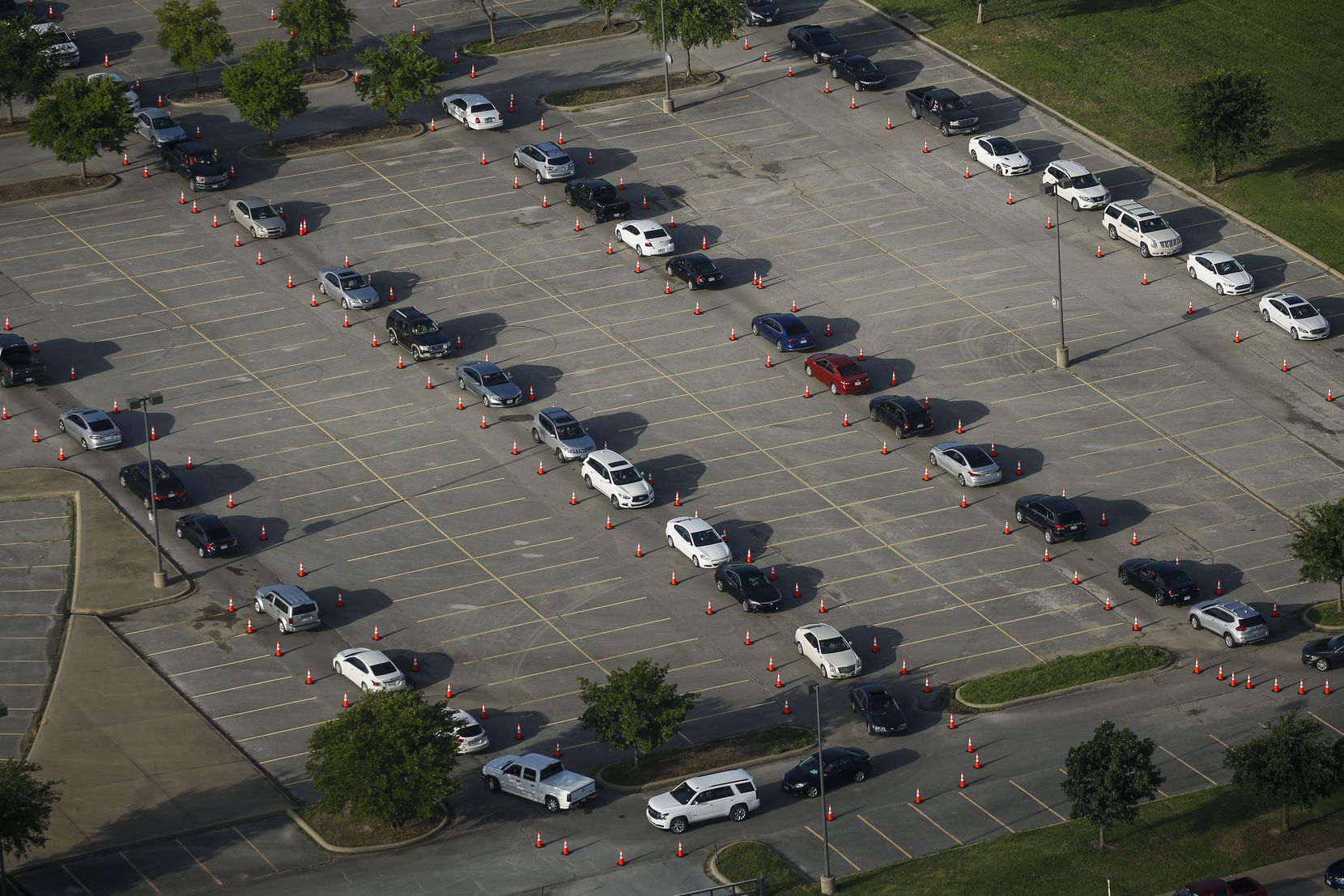 Cars make their way to the coronavirus testing tent at Ellis Davis Fieldhouse in Dallas on...