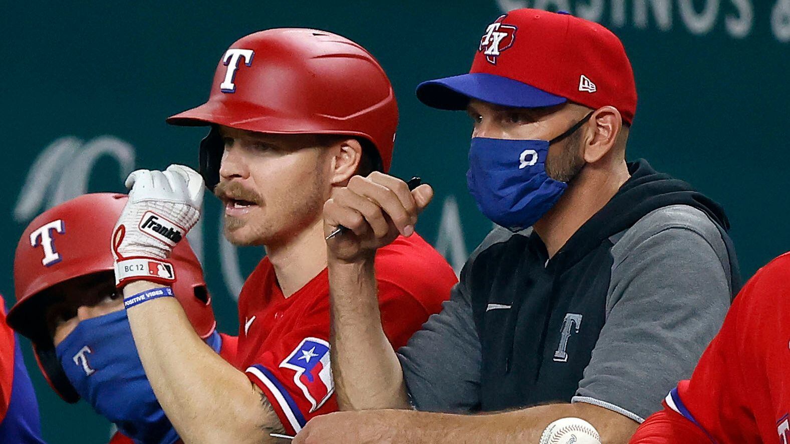 Texas Rangers third baseman Brock Holt (16) visits with manager Chris Wooward before his at-bat during the sixth inning at Globe Life Field in Arlington, Texas, Friday, April 30, 2021. The Rangers were facing the Boston Red Sox. (Tom Fox/The Dallas Morning News)