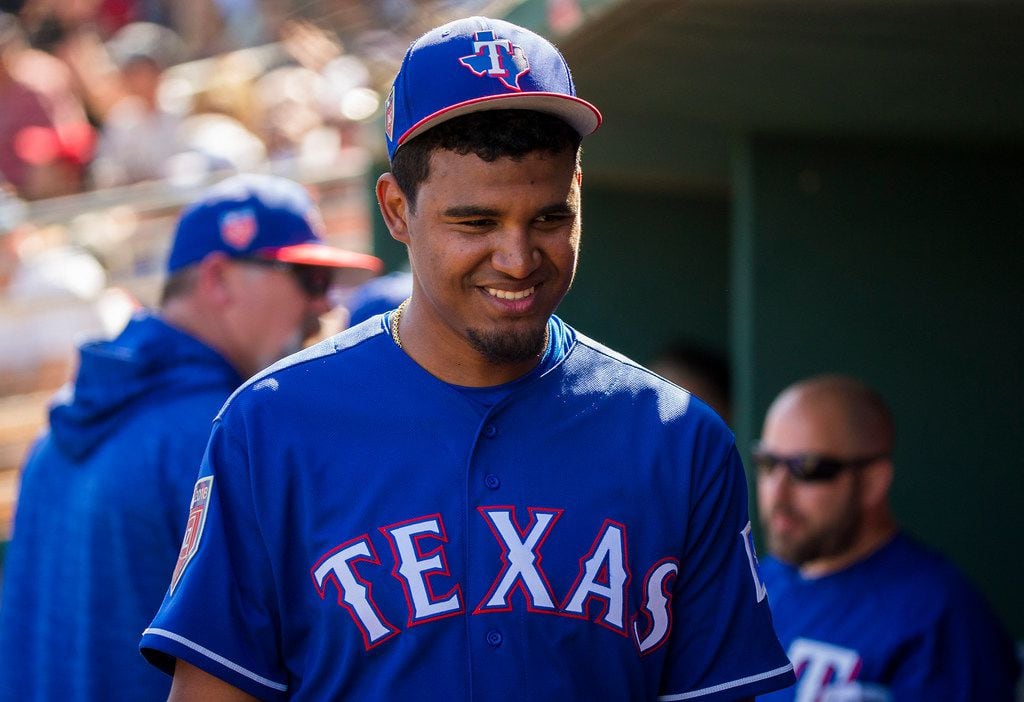 Texas Rangers pitcher Yohander Mendez smiles in the dugout during the third inning of a...