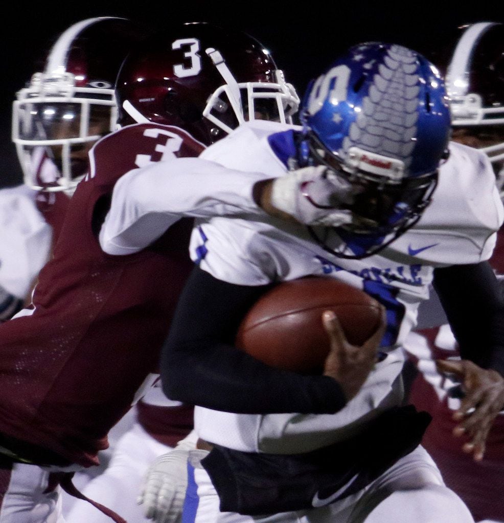 Seagoville quarterback Eric Hall Jr. (1) powers inside for tough yardage as he is tackled by...
