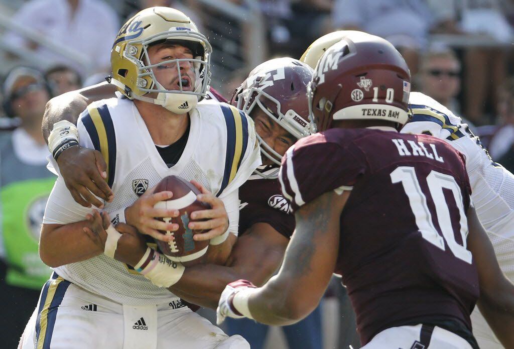 UCLA quarterback Josh Rosen (3) is sacked by Texas A&M defensive linemen Myles Garrett (15) and Daeshon Hall (10) in the third quarter during the UCLA Bruins vs. the Texas A&M Aggies NCAA football game at Kyle Field in College Station, Texas on Saturday, September 3, 2016. (Louis DeLuca/The Dallas Morning News)