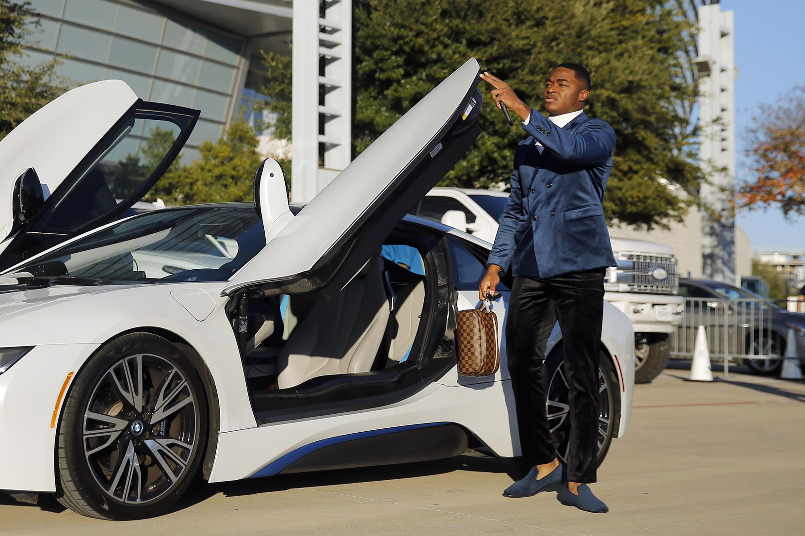 Dallas Cowboys wide receiver Amari Cooper closes the door on his BMW i8 as he arrives to...
